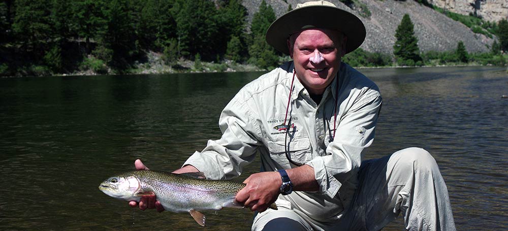 angler and large rainbow trout caught on a montana jet boat fishing trip