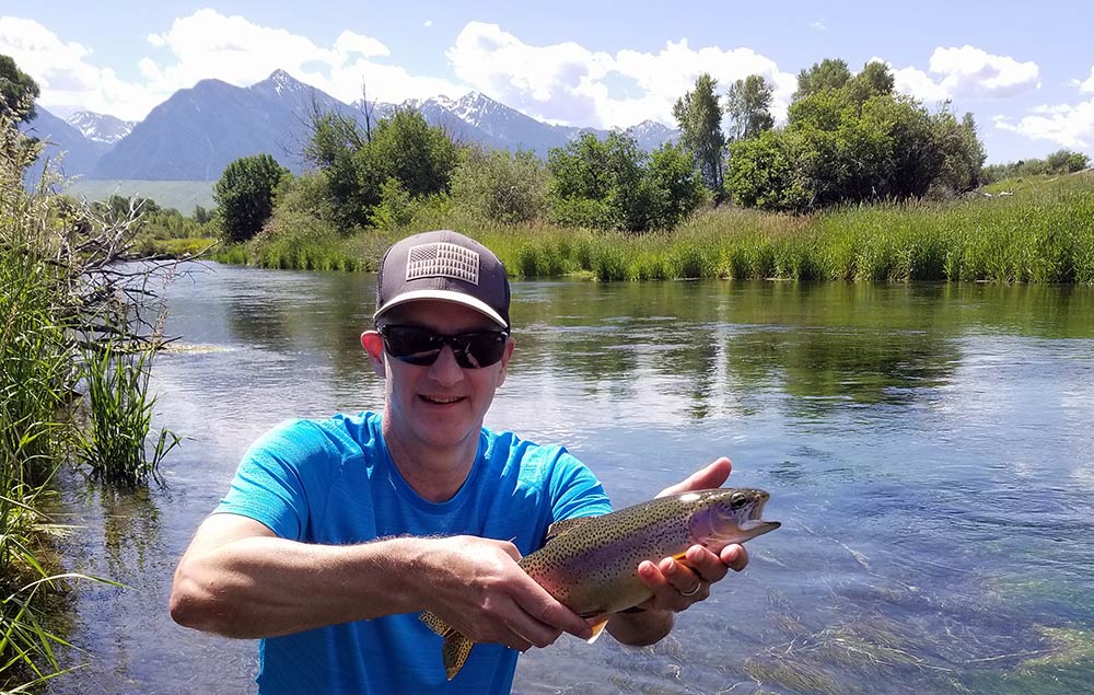 Paradise Valley spring creek, fishing client, and rainbow trout caught on a Montana private water fishing trip