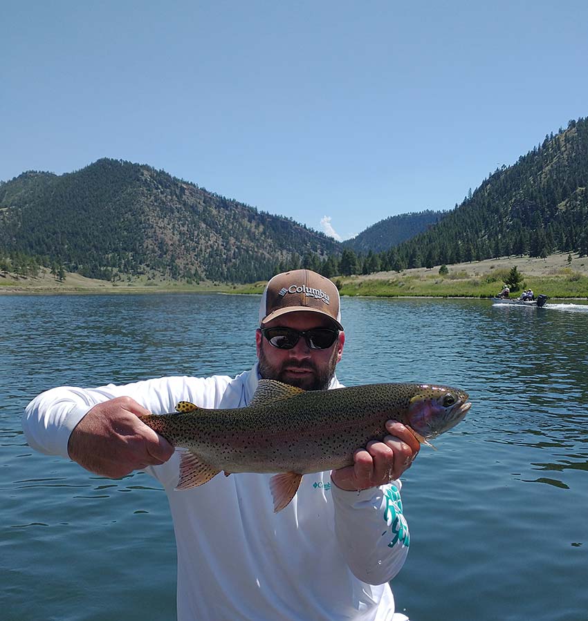 Missouri River rainbow trout. Mountains, river, and boat in background