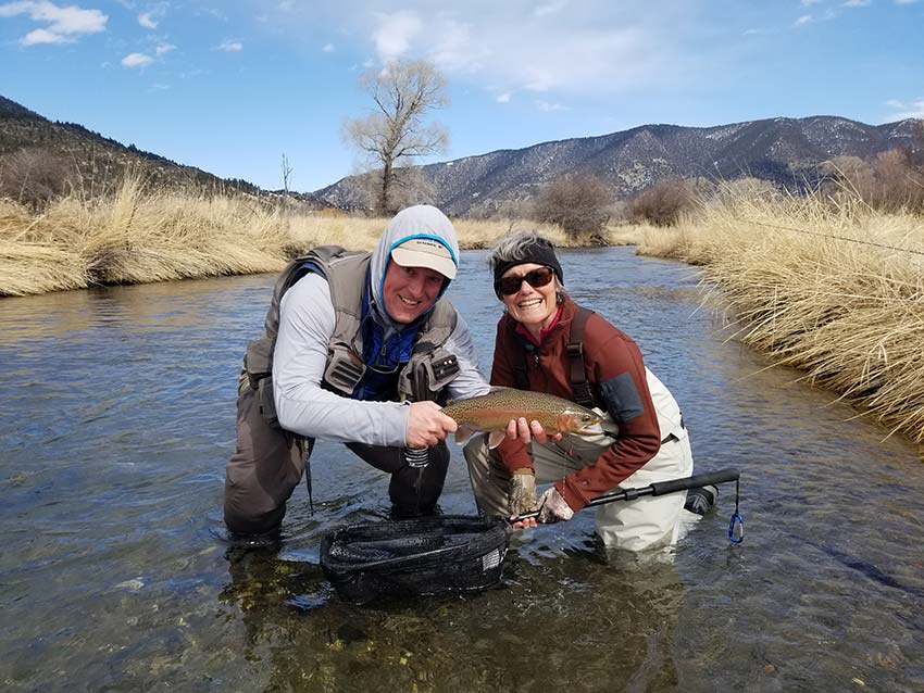 Depuy spring creek with rainbow trout and smiling angler