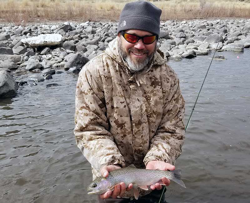 angler with early spring float-wade rainbow