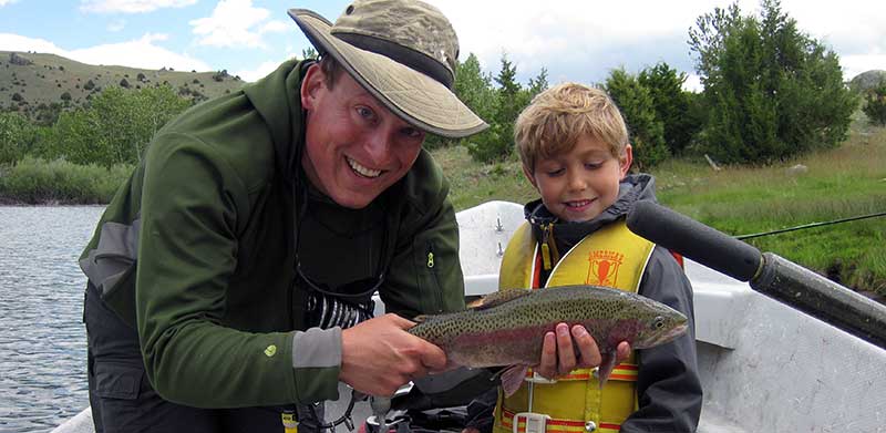 young angler with large rainbow trout
