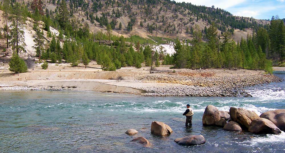 angler fishing Grand Canyon of the Yellowstone in autumn