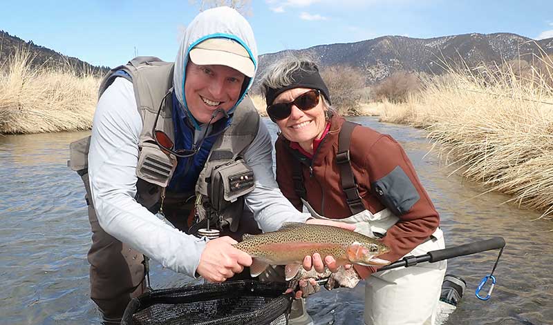 angler with spring creek rainbow