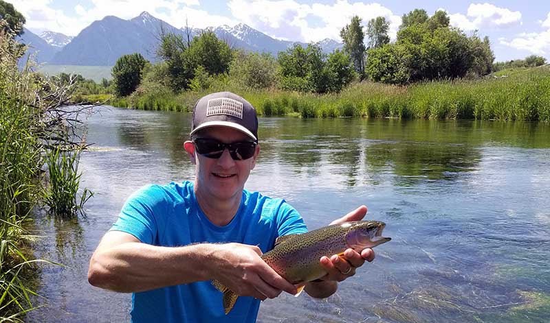 angler with spring creek rainbow