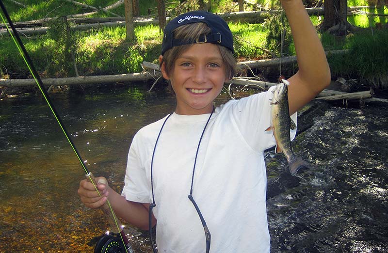 beginner fisherman holding a brook trout