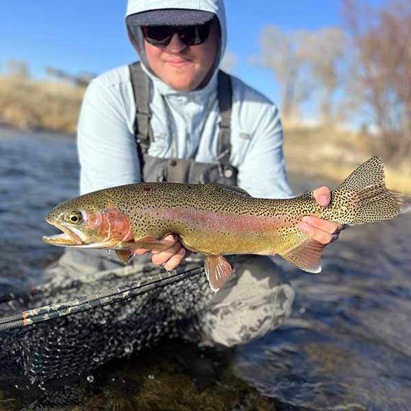 guide brendan cooke with a large rainbow trout