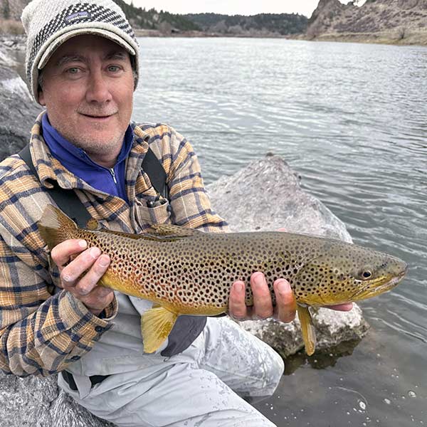 image of dustin gaines holding a large brown trout
