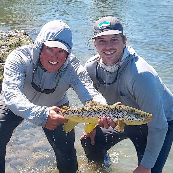 angler, guide, and large brown trout.